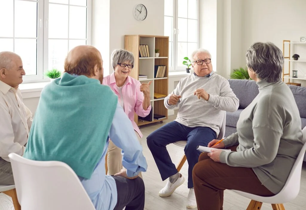 Older adults talking together in a bright living room