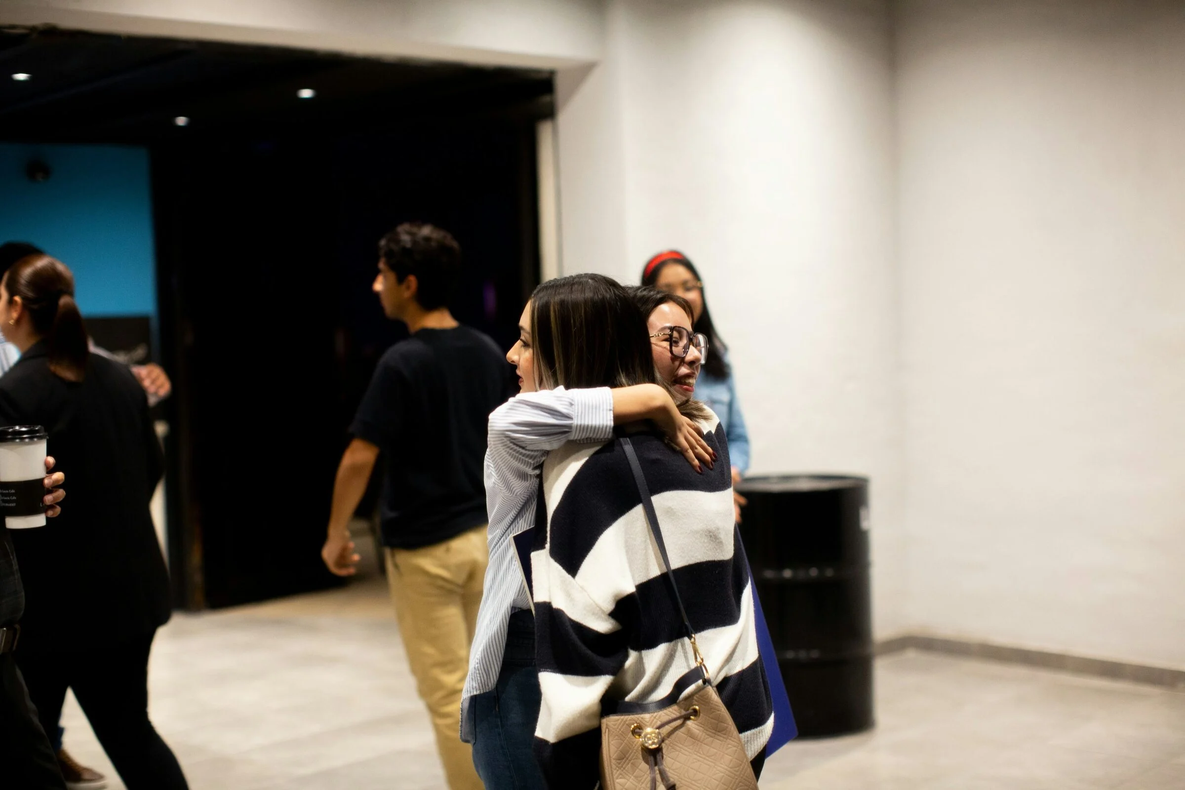 Two friends sharing a welcome hug in the church lobby