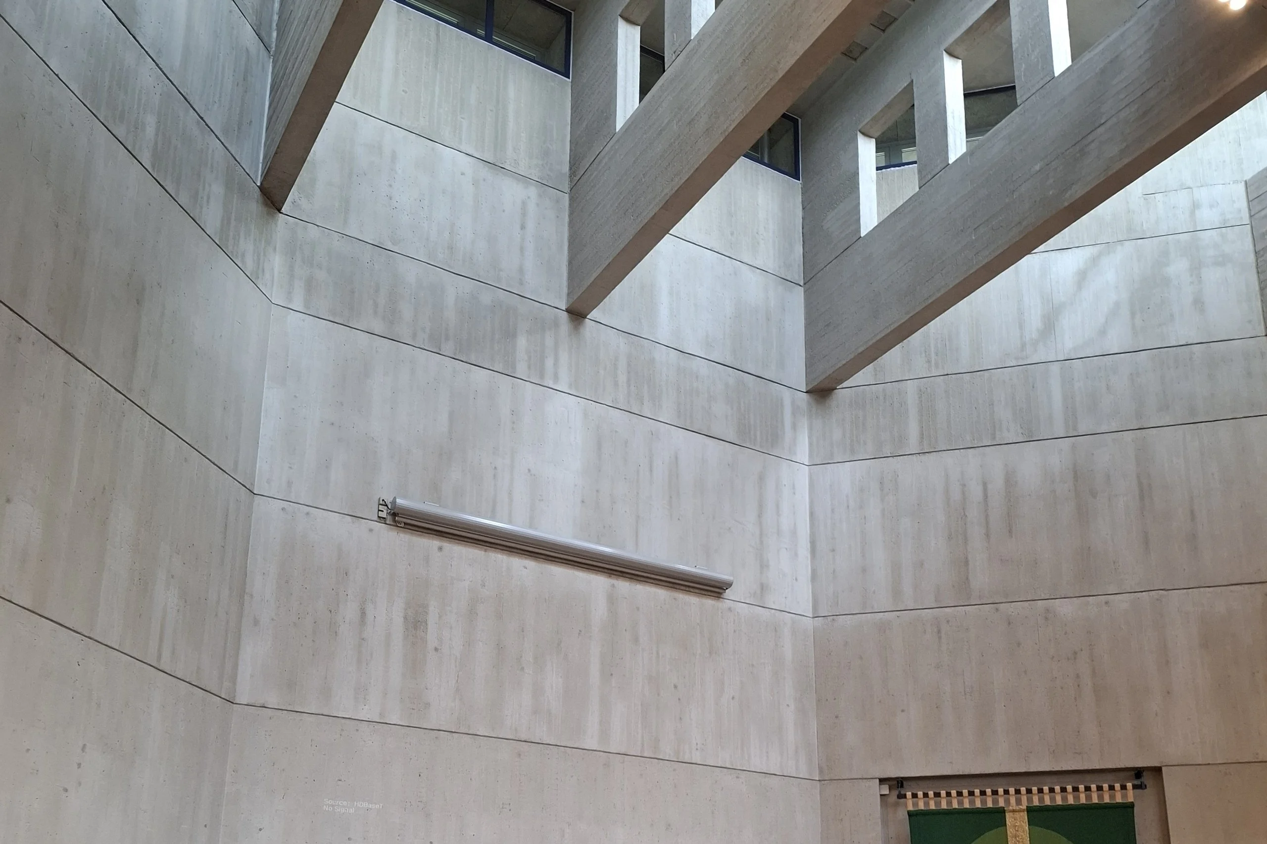 Tall concrete church interior lit from high windows